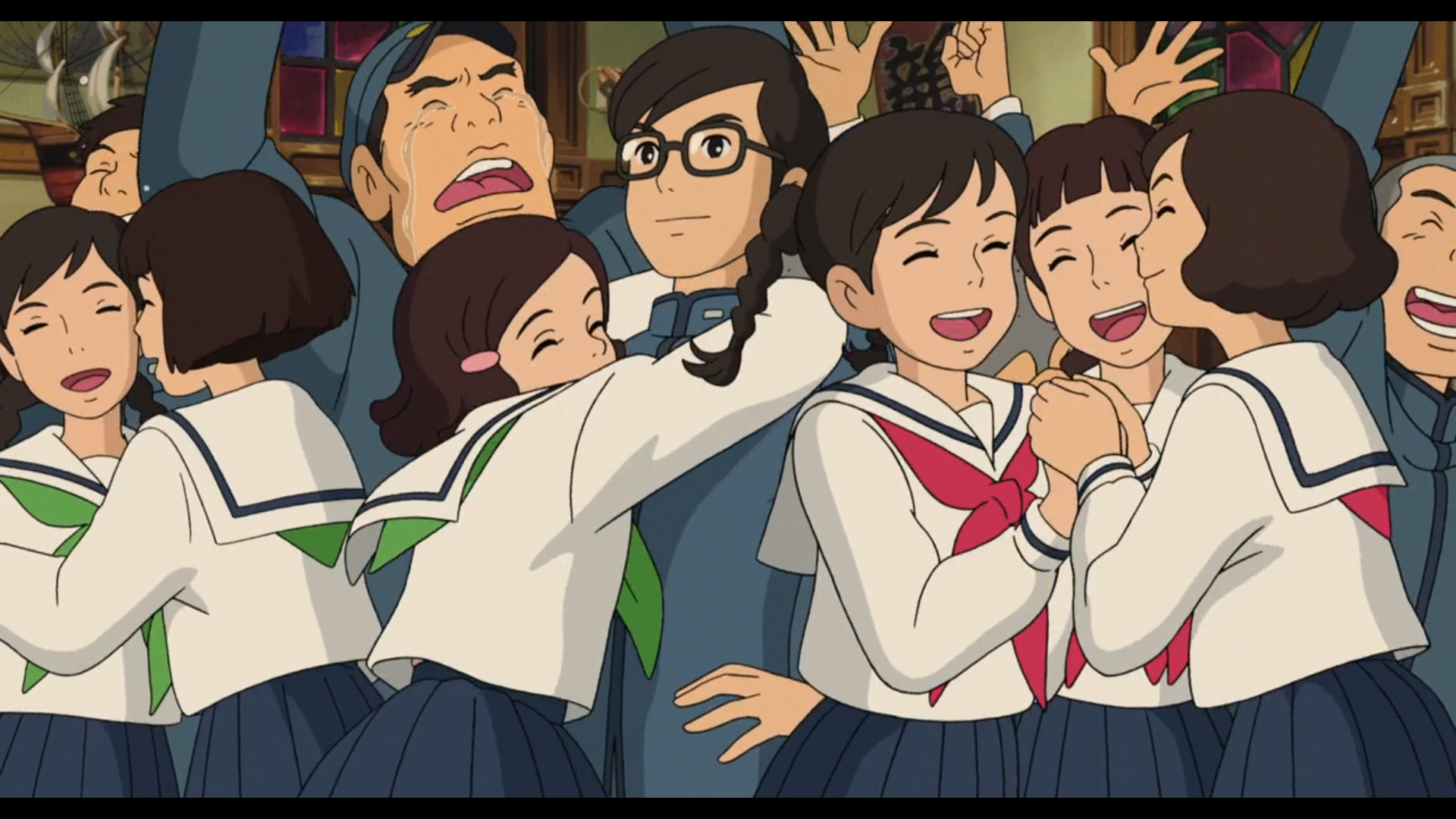Scène de la Colline aux Coquelicots
Plusieurs étudiant.e.s japonais.es en uniforme sont en liesse
Au premier plan, de gauche à droite, deux filles avec une chemise blanche, un genre de cape blanche avec un trait bleu au bord, une jupe bleu foncé et un ruban vert autour du cou se prennent dans les bras, en fermant les yeux; puis une fille avec le même uniforme et une broche rose dans les cheveux saute au cou d'un garçon avec une chemise bleue, portant des lunettes, se tenant les mains sur les hanches et affichant un sourire satisfait, c'est le seul personnage de la scène avec les yeux ouverts; puis trois filles avec un uniforme presque identique à l'exception du ruban rose, se tiennent les mains, l'air joyeux.
A l'arrière plan, on distingue plusieurs autres étudiants, dont un à la mâchoire carrée, casquette bleue vissée sur la tête, laissant échapper des larmes. Tous lèvent les bras en signe de victoire.
On distingue des murs blancs et des fenêtres aux verres colorés comme des vitraux, indiquant qu'on dans le hall d'un gros bâtiment [le "Quartier latin"].