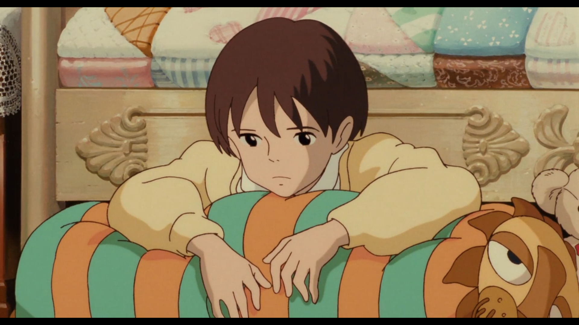 Scène de Si tu tends l'oreille
Shizuku, adolescente japonaise de 14-15 ans, aux cheveux noirs et yeux noirs, portant un pull jaune pâle et une chemise blanche, tenant sous ses bras un genre d'édredon rayé vert et orange qui se finit à son extrémité sur un lion, sur le quel elle semble s'avachir. Elle arbore une mine triste.
En arrière plan, on distingue un lit en bois peint en blanc cassé avec des couvertures où la couleur rose prédomine, ainsi que l'oreille d'un ours en peluche.